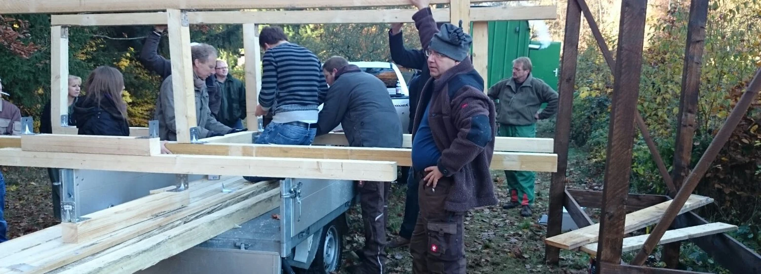Teilnehmer bauen gemeinsam eine Kanzel im Wald